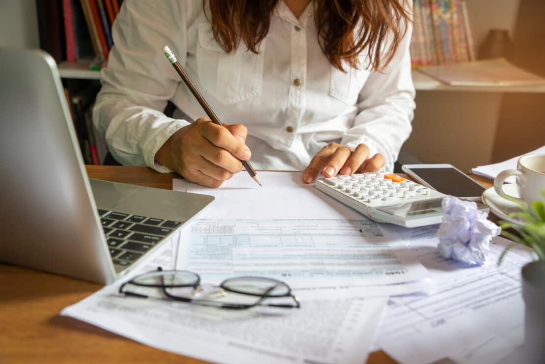 Accountant reviewing tax documents and calendar at office desk